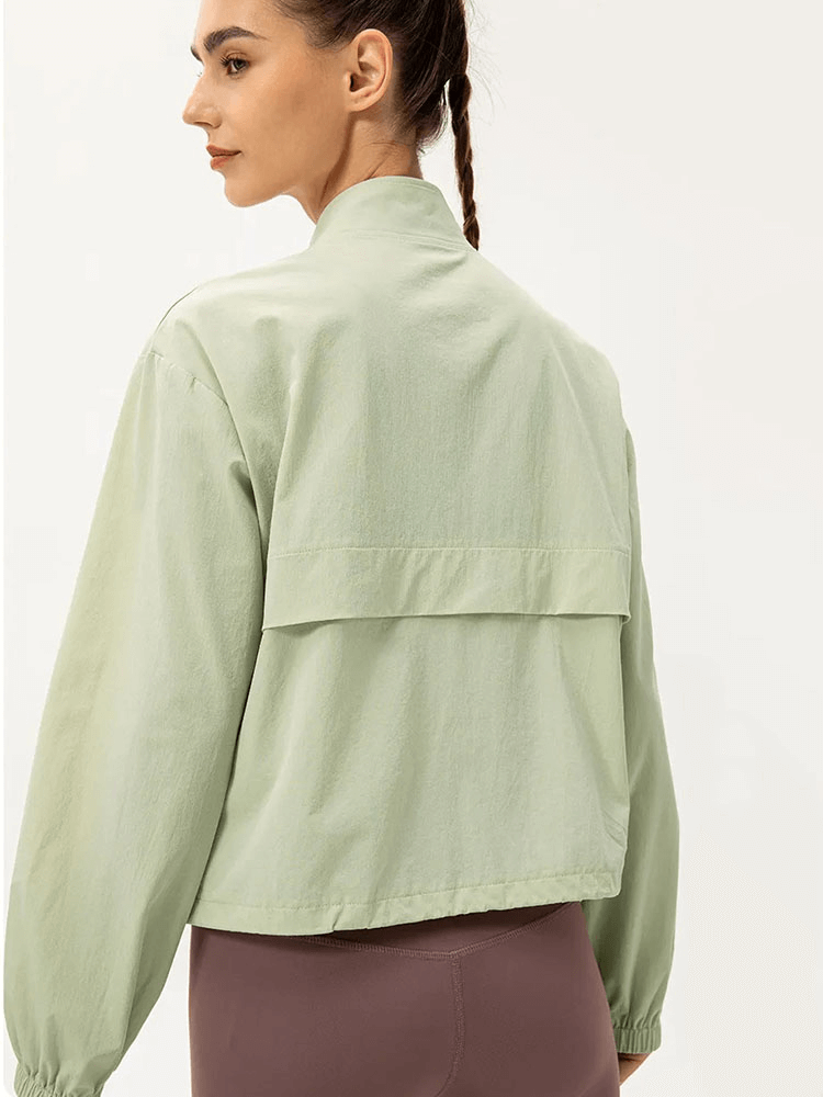 Woman wearing a mint green UV protection running windbreaker, showing back design and turn-down collar, perfect for outdoor activities.